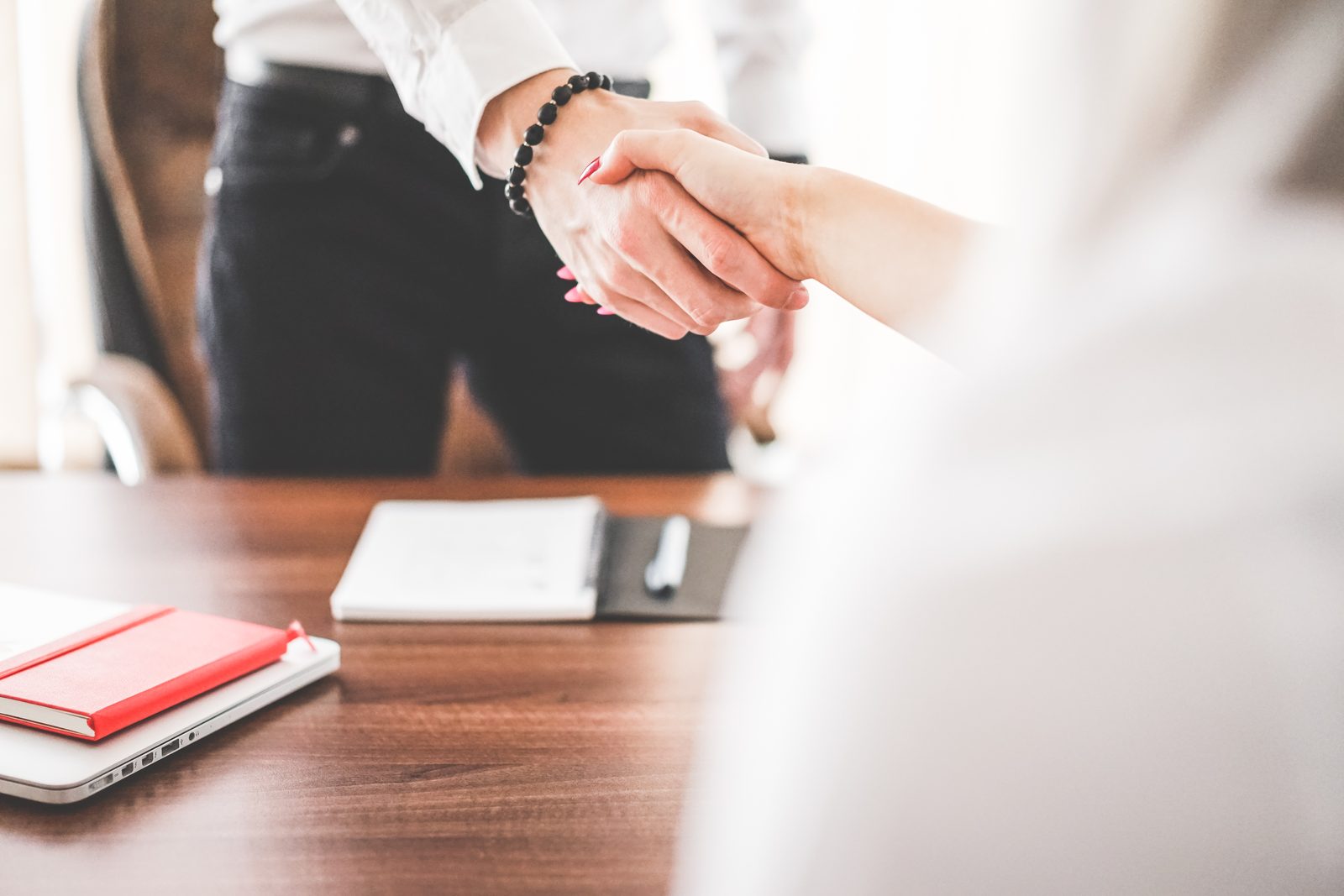 Two people shaking hands in an office